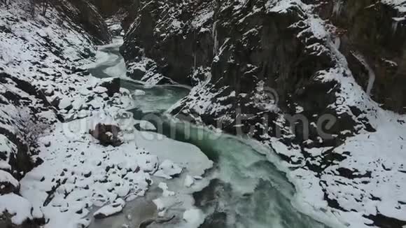 高加索山脉积雪峡谷底部快速流动的绿松石水视频的预览图