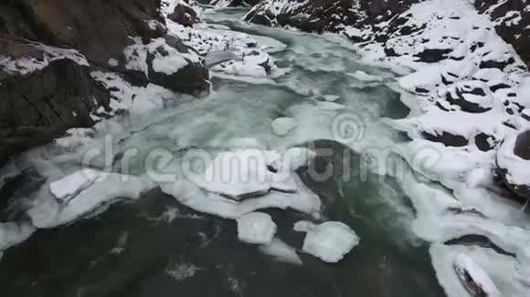 俄罗斯高加索山脉积雪峡谷底部的一条快速山涧的绿松石水视频的预览图