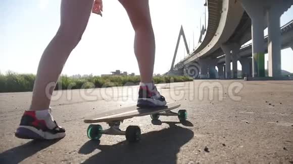 年轻女子漂亮的腿在外面玩滑板阳光明媚视频的预览图