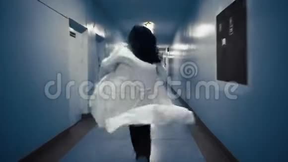 穿着白色外套的女人沿着一条黑暗的走廊跑从后面看视频的预览图