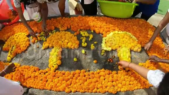 在一个古老的宗教中心女人们在白色佛塔上美丽地放着橙色的花作为礼物送给佛陀视频的预览图