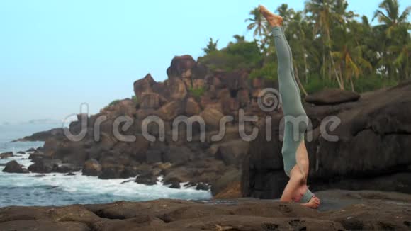 女人站在靠近海洋的平石上视频的预览图