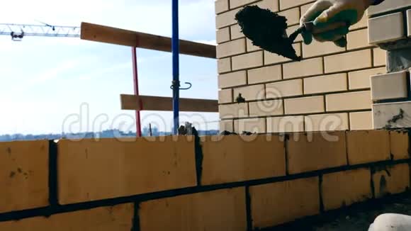 一个人在建房子时铺砖砖匠在一个建筑工地做砌砖工作视频的预览图