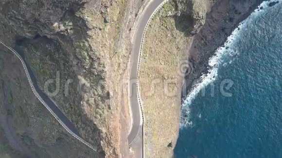 在西班牙特内里费空中无人机拍摄到一条空路沿着海角垂直悬悬的悬崖延伸到海洋上视频的预览图