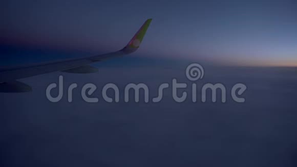 在飞机内观看乘客窗口座位飞机机翼令人惊叹的日落日出金色的云视频的预览图