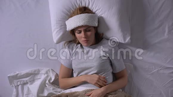 生病的女孩咳嗽躺在床上额头湿敷季节性流感视频的预览图