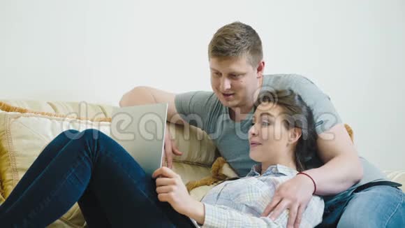 年轻夫妇通过笔记本电脑与家人视频聊天视频的预览图