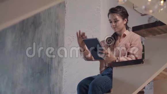 年轻女子用数码平板电脑休息库存录像穿着粉红色衬衫的美丽微笑女人的特写视频的预览图
