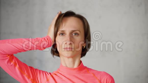 健身妇女展示颈部和肩部放松体操疼痛视频的预览图
