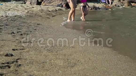 与母亲在沙滩上奔跑的幼儿女孩视频的预览图