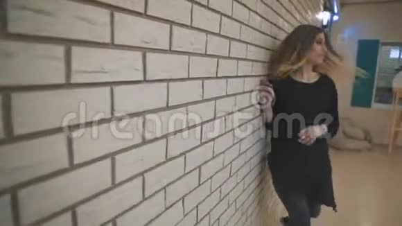 舞者年轻有才华的女人在白色砖墙前跳舞和表演自由式舞蹈视频的预览图