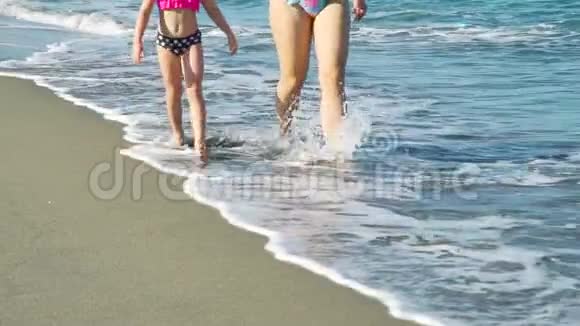 与妈妈在沙滩上散步的小女孩亲密视频的预览图