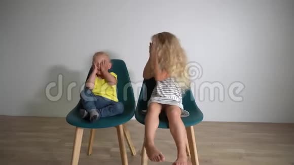 嬉闹的小朋友兄妹坐在椅子上捂着眼睛看着镜头视频的预览图