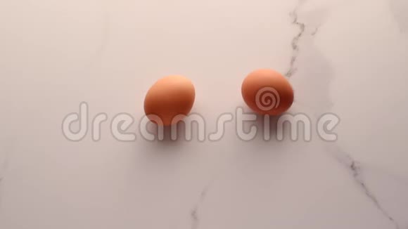 大理石桌上的鸡蛋作为最低限度的食物平躺顶部看食品品牌的视频平躺和烹饪的食谱视频的预览图