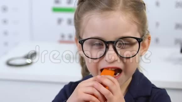可爱的戴眼镜的女孩子吃胡萝卜视力护理胡萝卜素维生素视频的预览图