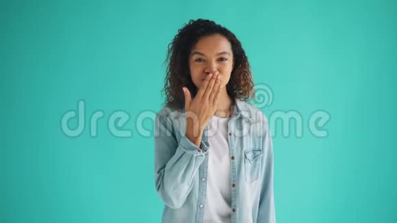 迷人的非裔美国女孩送空气亲吻和微笑眨眼的肖像视频的预览图