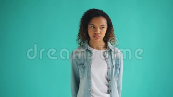一个悲伤的非洲裔美国女孩独自站着脸上带着不愉快的表情视频的预览图