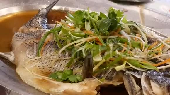 蒸鲈鱼与草药和蔬菜在白菜中的运动视频的预览图