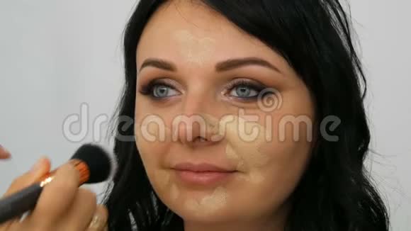 在美容院化妆厅模特儿脸上涂粉底视频的预览图