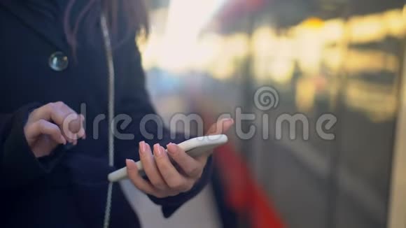 女人在电话和火车上查看目的地在线购票应用程序视频的预览图