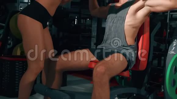 女教练帮助健身房里的男人运动健身生活方式美容理念在电影院的摄像机上拍摄视频的预览图