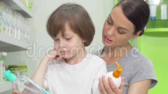 美丽的女人和她的儿子在药店里挑选两种产品视频的预览图