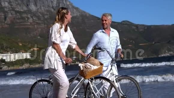 带着自行车在海滩上散步的免费情侣视频的预览图