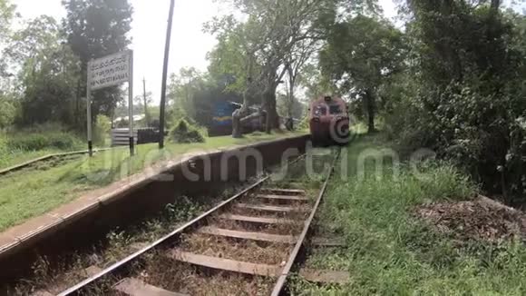 经过斯里兰卡丛林的火车一个小车站和一辆旧火车头铁轨靠近古老的佛教城市阿努拉德视频的预览图
