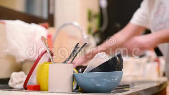 女孩不专心地洗盘子把注意力集中在一堆脏盘子上视频的预览图