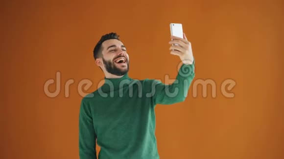 一张长胡子的帅哥用智能手机相机自拍的画像视频的预览图