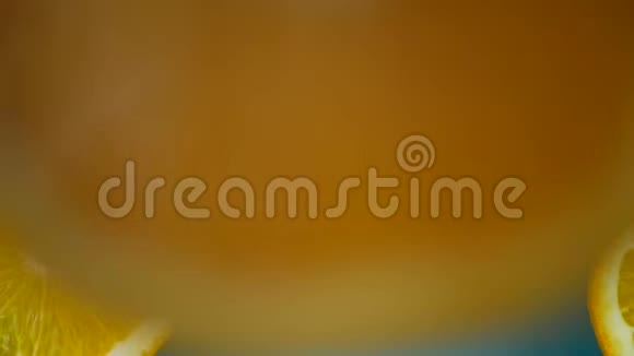 蓝色背景下落入水中的鲜橙果片组视频的预览图