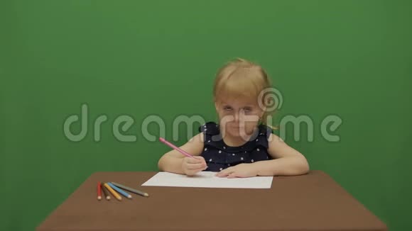 女孩在桌子边画画快乐的三岁女孩可爱的女孩微笑棕色的眼睛一个漂亮的小孩34岁的女孩视频的预览图