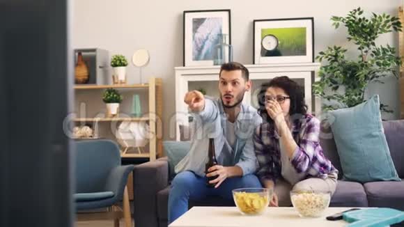 一对夫妇在电视上看体育节目然后做击掌和拥抱视频的预览图