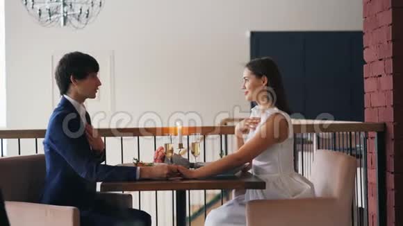在求婚过程中在餐馆里看到一对幸福的夫妻男人在说话把订婚戒指戴在女孩身上视频的预览图