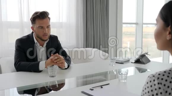 不开心的男人和坐在桌子旁的心理学家沮丧的男人谈论与女人的问题视频的预览图