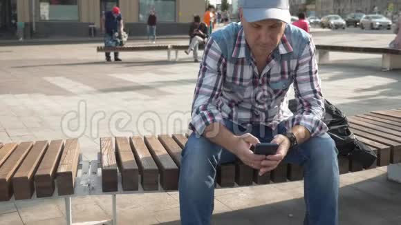 白种人坐在长凳上写短信视频的预览图