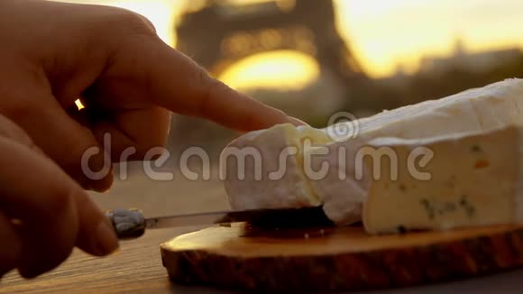 手拿一块布里干酪在埃菲尔铁塔旁边视频的预览图