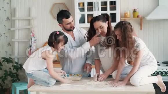 快乐的家庭在厨房做饭妈妈准备面团烘焙慢动作视频的预览图