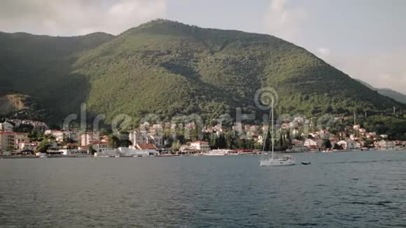 这艘游艇正在黑山的亚得里亚海航行背景是美丽的山脉视频的预览图