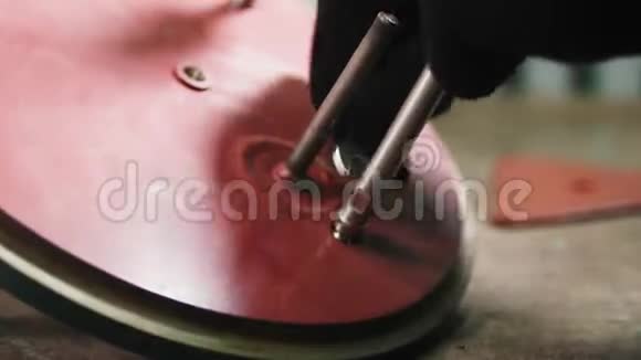 工人螺丝粘在木桌上的红色金属细节上视频的预览图
