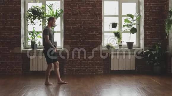 帅哥准备做晨练瑜伽男性手持黑色瑜伽垫视频的预览图