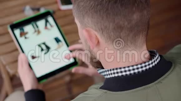 男人在他的花哨平板电脑上网上购物视频的预览图