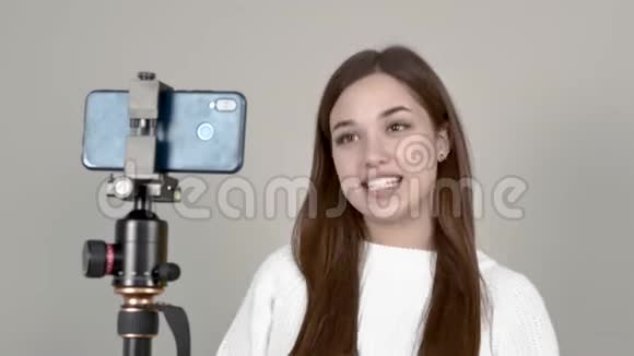 白人女孩博主站在手机摄像头前录制视频视频的预览图