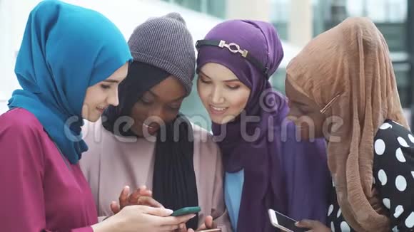 一群多种族穆斯林女商人聊天休息时查看智能手机上的新闻提要视频的预览图