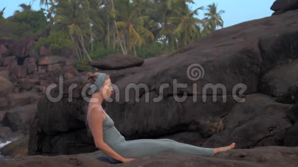 女孩在大平岩石上的后空翻慢动作视频的预览图