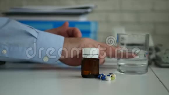 商务人员安排办公桌上的药品和带头疼水的玻璃杯视频的预览图