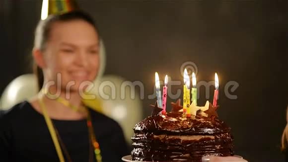 在卡普的漂亮女士正在吹出她的生日蜡烛巧克力蛋糕和苹果微笑的女人视频的预览图
