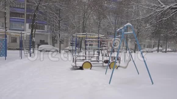 冬天一栋住宅的庭院里有一个游乐场它下雪了背景很好动作很慢视频的预览图
