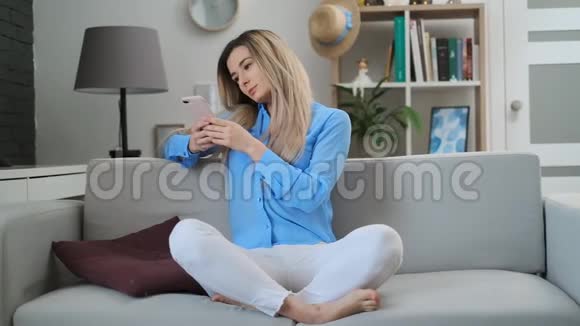 美丽的女孩使用数字移动设备浏览互联网和社交媒体呆在家里享受连接视频的预览图