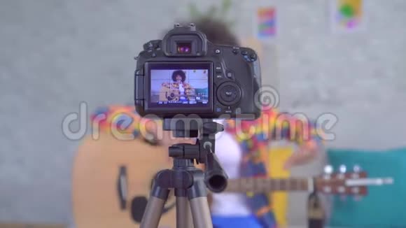 非洲女性博客写手的发型是非洲式的通过相机屏幕可以看到吉他视频的预览图